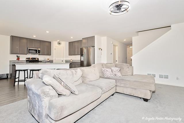 living room with baseboards, recessed lighting, stairs, and visible vents