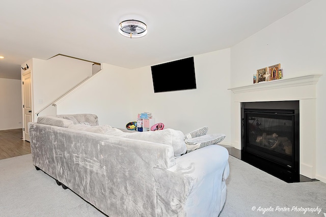 living area with carpet flooring and a fireplace with flush hearth
