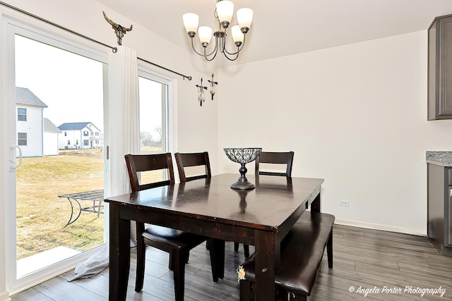 dining area featuring baseboards, a notable chandelier, and dark wood finished floors