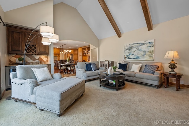 living area with high vaulted ceiling, light colored carpet, a chandelier, arched walkways, and beamed ceiling