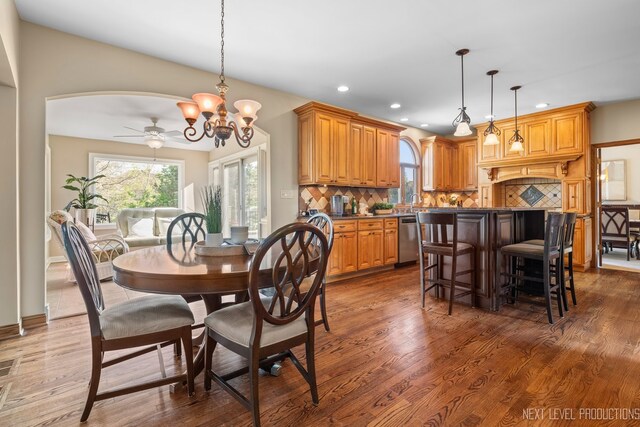 dining space with plenty of natural light, a chandelier, recessed lighting, and wood finished floors