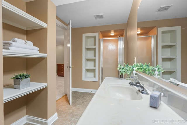 full bathroom featuring baseboards, tile patterned floors, built in features, a stall shower, and vanity
