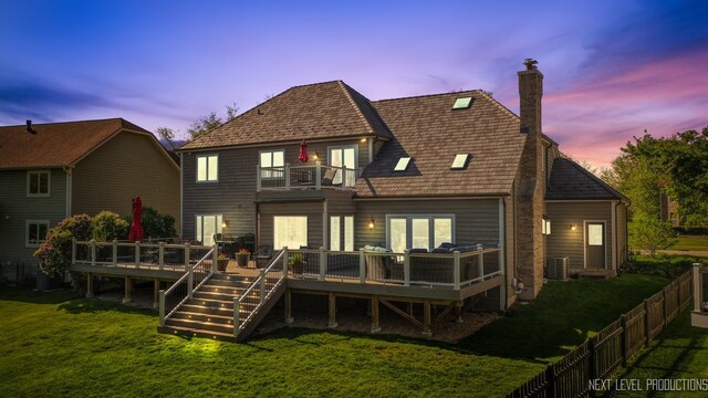 back of house featuring a balcony, a chimney, and a deck