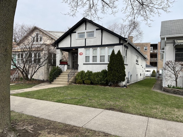 tudor home with stucco siding and a front yard