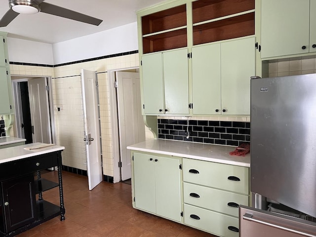 kitchen with freestanding refrigerator, light countertops, ceiling fan, dark tile patterned flooring, and green cabinetry