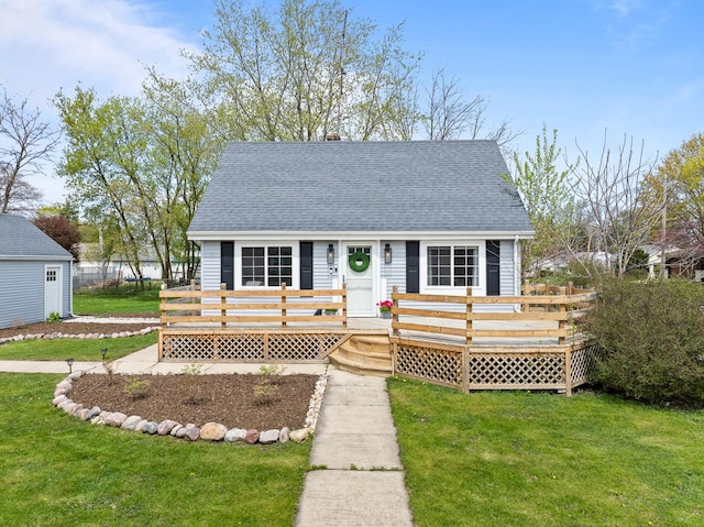 112 E Page St, Elkhorn, WI 53121 - view of front facade featuring roof with shingles, a wooden deck, and a front yard