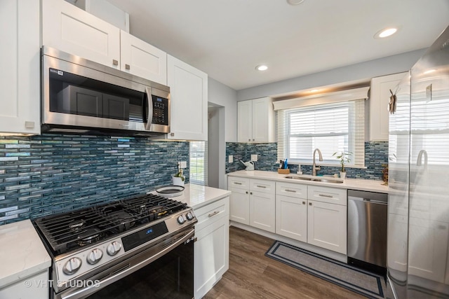3917 Home Ave, Stickney, IL 60402 - kitchen with appliances with stainless steel finishes, a sink, white cabinets, dark wood finished floors, and tasteful backsplash