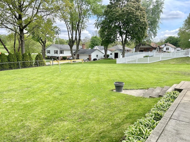 view of yard featuring fence and a residential view