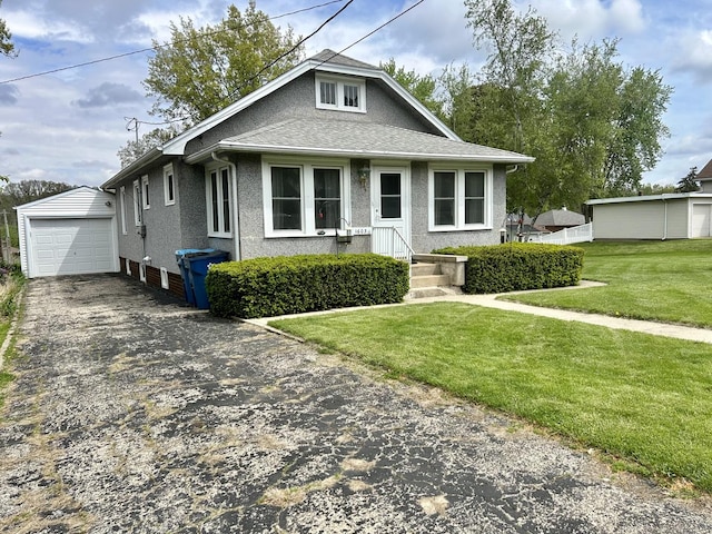 view of front of house featuring an outdoor structure, a front lawn, driveway, and a detached garage