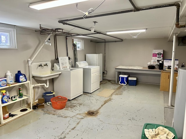 washroom with a sink, laundry area, washing machine and dryer, and a garage