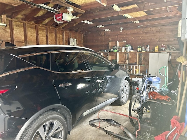garage with wooden walls and a garage door opener