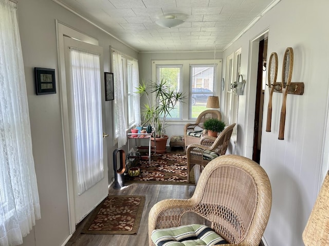 sunroom featuring ornamental molding and wood finished floors
