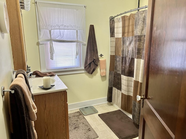 bathroom featuring baseboards, vanity, and a shower with shower curtain