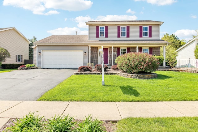 2825 Colonial Dr, Elgin, IL 60124 - traditional home with a garage, asphalt driveway, a front lawn, and covered porch