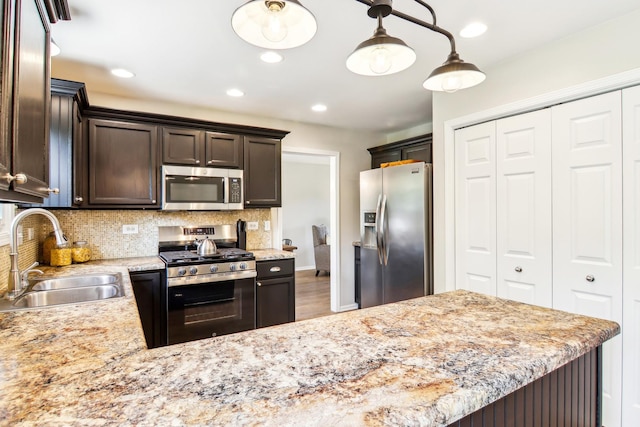 2825 Colonial Dr, Elgin, IL 60124 - kitchen featuring stainless steel appliances, a sink, dark brown cabinets, decorative backsplash, and light stone counters