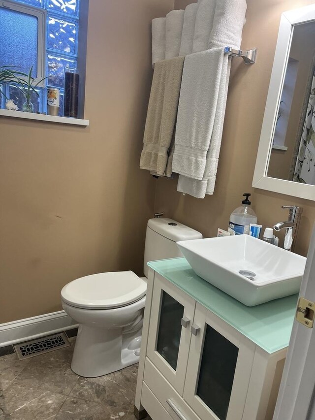 2126 N Kostner Ave, Chicago, IL 60639 - half bathroom featuring visible vents, baseboards, toilet, and vanity