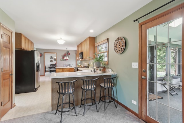 2835 Randall Ridge Ct, Elgin, IL 60124 - kitchen featuring stainless steel fridge with ice dispenser, a peninsula, light countertops, black microwave, and a sink