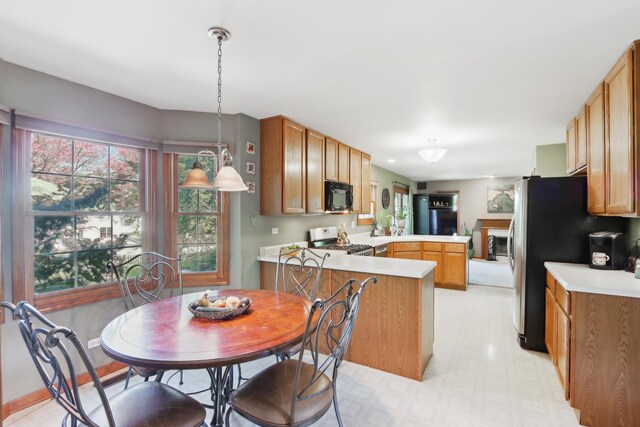 2835 Randall Ridge Ct, Elgin, IL 60124 - kitchen with stainless steel appliances, a peninsula, light countertops, pendant lighting, and brown cabinetry