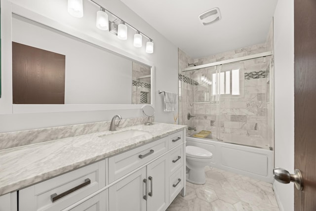bathroom featuring visible vents, vanity, marble finish floor, toilet, and combined bath / shower with glass door