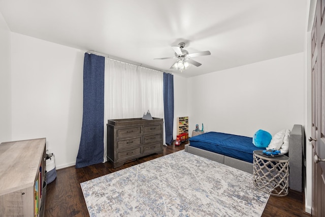 bedroom with baseboards, a ceiling fan, and dark wood-style flooring