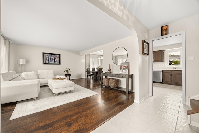 living area with an inviting chandelier, arched walkways, and baseboards