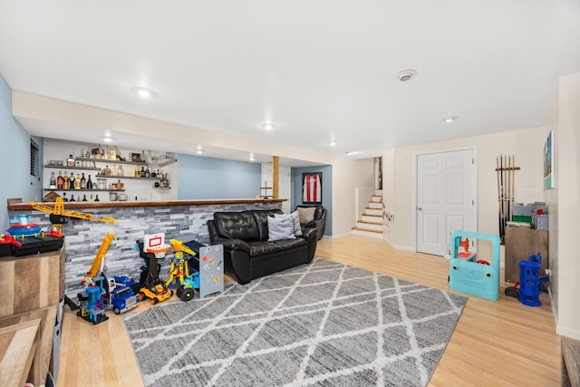 living room featuring recessed lighting, a dry bar, stairs, and wood finished floors