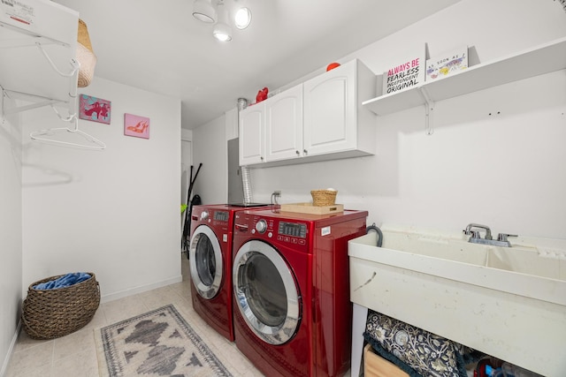 laundry room with cabinet space, light tile patterned floors, a sink, baseboards, and washer and clothes dryer
