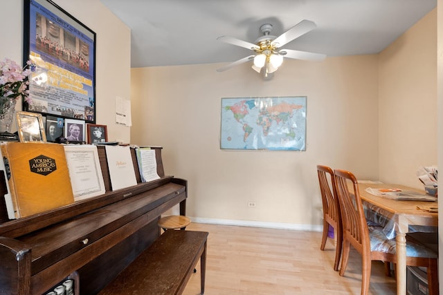 dining area featuring light wood finished floors, baseboards, and ceiling fan