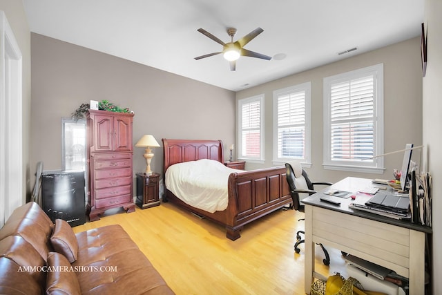 bedroom with visible vents, a ceiling fan, and light wood-style flooring