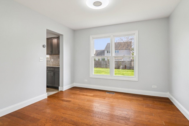 unfurnished dining area with light wood-type flooring, baseboards, and a healthy amount of sunlight