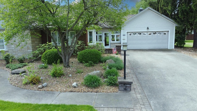 view of front facade with concrete driveway, stone siding, and an attached garage