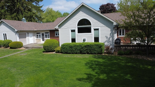 view of front of home featuring fence, a garage, and a front yard