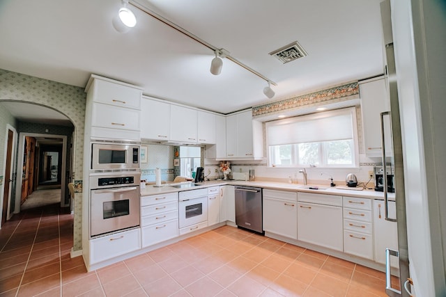 kitchen featuring light tile patterned flooring, light countertops, stainless steel appliances, and visible vents