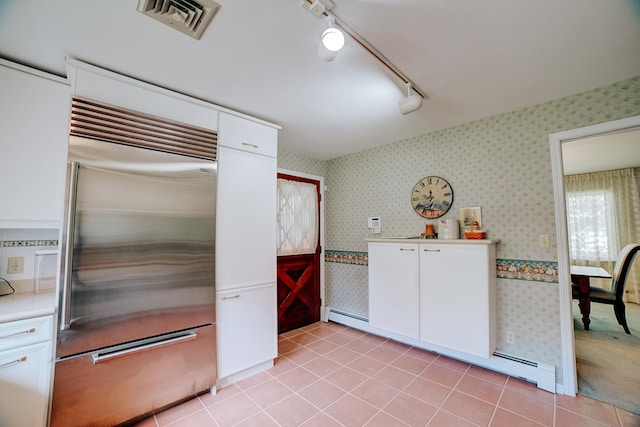 kitchen with wallpapered walls, visible vents, rail lighting, white cabinetry, and built in refrigerator