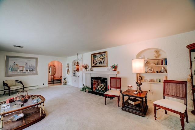carpeted living area with a fireplace, arched walkways, baseboard heating, and visible vents