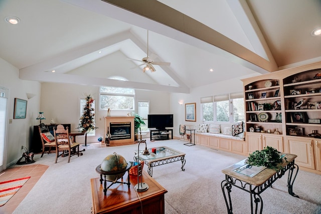 living room featuring a healthy amount of sunlight, high vaulted ceiling, a glass covered fireplace, and beam ceiling