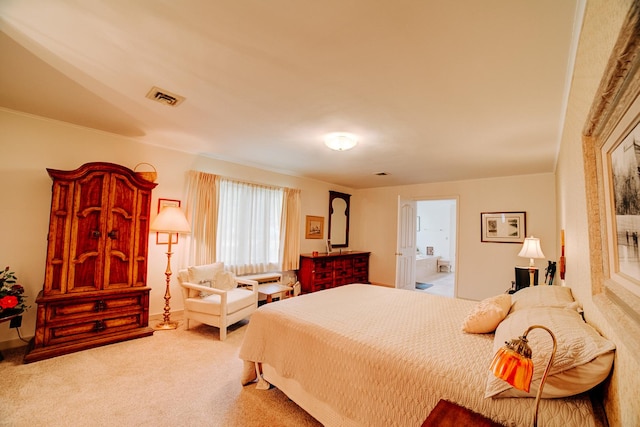 carpeted bedroom featuring ensuite bathroom and visible vents
