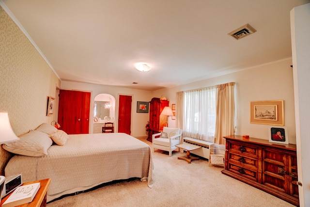 carpeted bedroom with crown molding, arched walkways, and visible vents