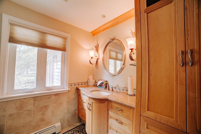 bathroom with tile walls, baseboard heating, vanity, and a wainscoted wall