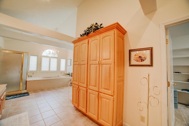full bathroom with lofted ceiling, a shower stall, tile patterned flooring, a garden tub, and vanity
