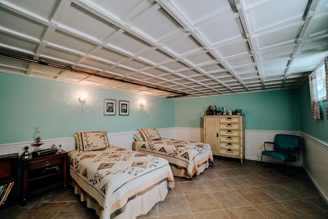tiled bedroom featuring wainscoting
