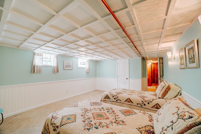 tiled bedroom with baseboards and a wainscoted wall