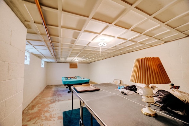 playroom featuring unfinished concrete floors and concrete block wall