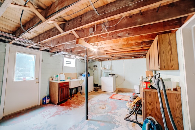 below grade area with washing machine and dryer, plenty of natural light, and a sink