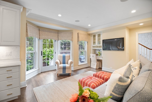 living area with ornamental molding, dark wood finished floors, baseboards, and recessed lighting