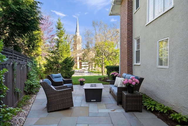 view of patio / terrace featuring fence and an outdoor living space with a fire pit
