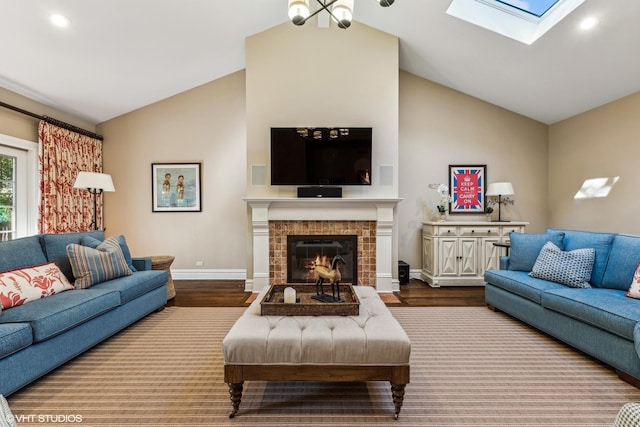 living area with lofted ceiling, wood finished floors, baseboards, a skylight, and a tile fireplace