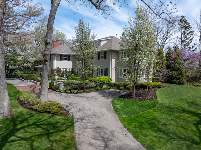 view of home's community featuring a yard and curved driveway