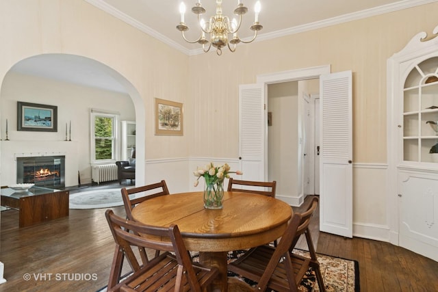 625 Greenbriar Ln, Lake Forest, IL 60045 - dining space featuring radiator heating unit, dark wood-style floors, arched walkways, a chandelier, and crown molding