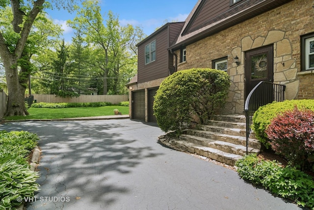625 Greenbriar Ln, Lake Forest, IL 60045 - view of property exterior featuring a garage, asphalt driveway, and stone siding